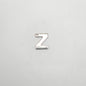 Silver letter 'Z' charm on a light gray background