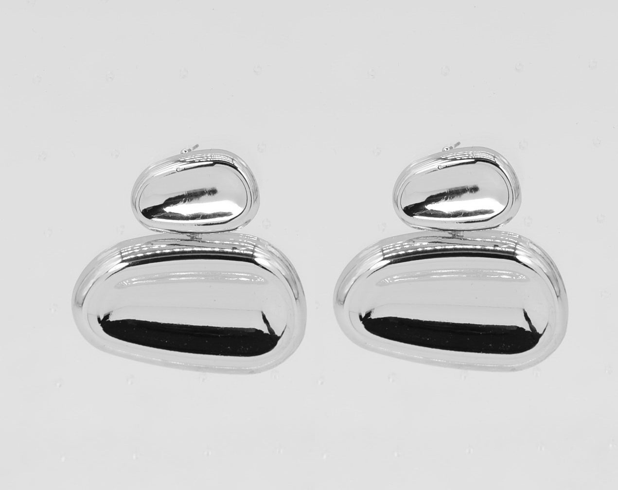Pair of silver earrings on a light gray background