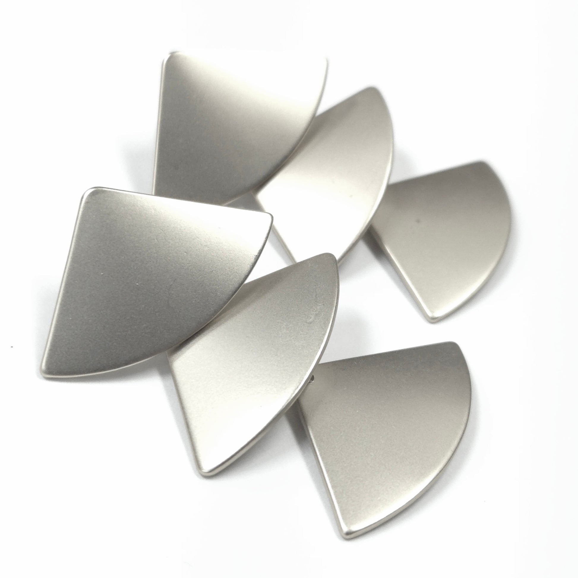 Metallic silver guitar picks on a white background