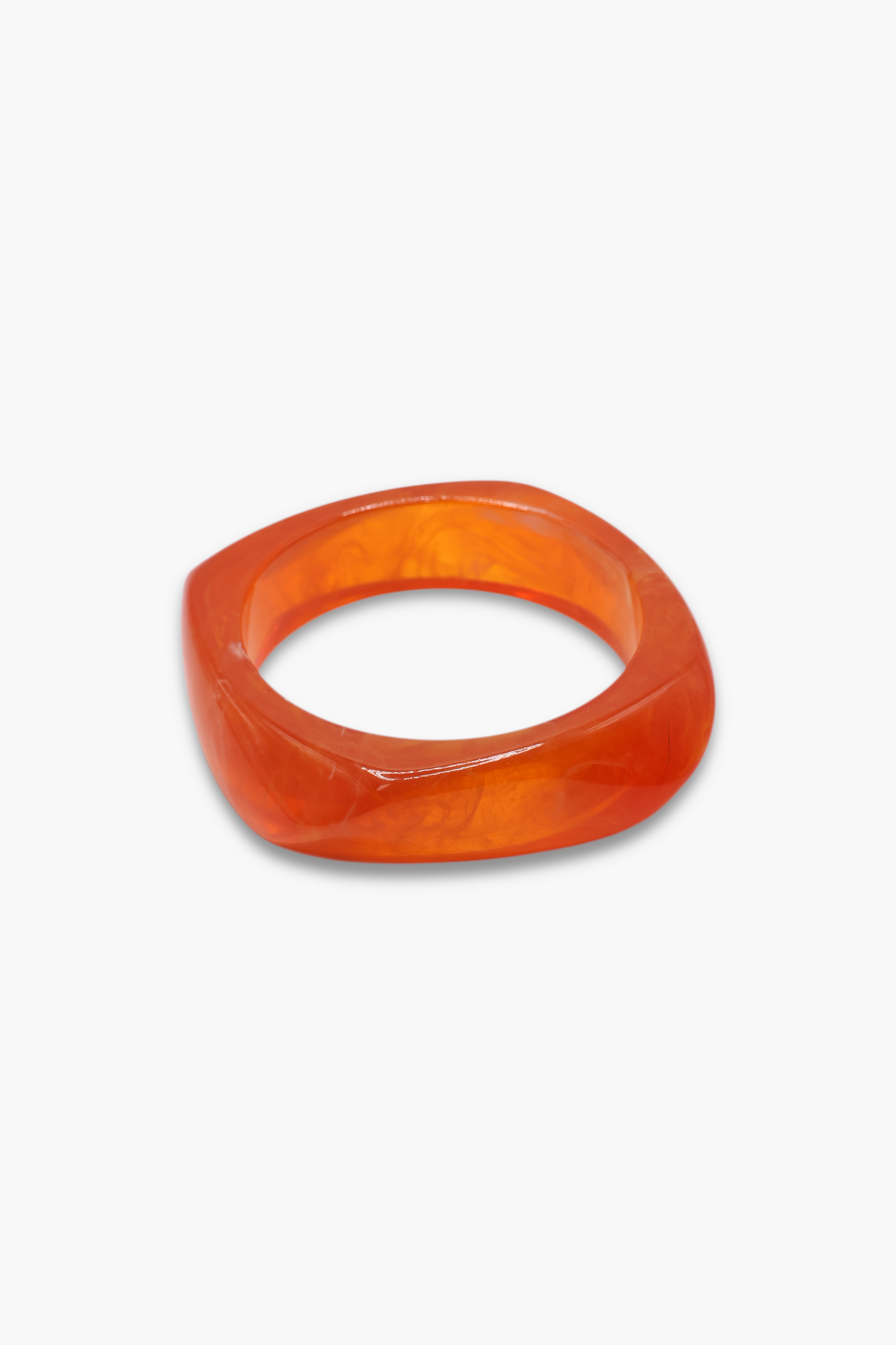 Minimalist marbled resin bangle bracelet with rounded square shape and polished glossy finish.