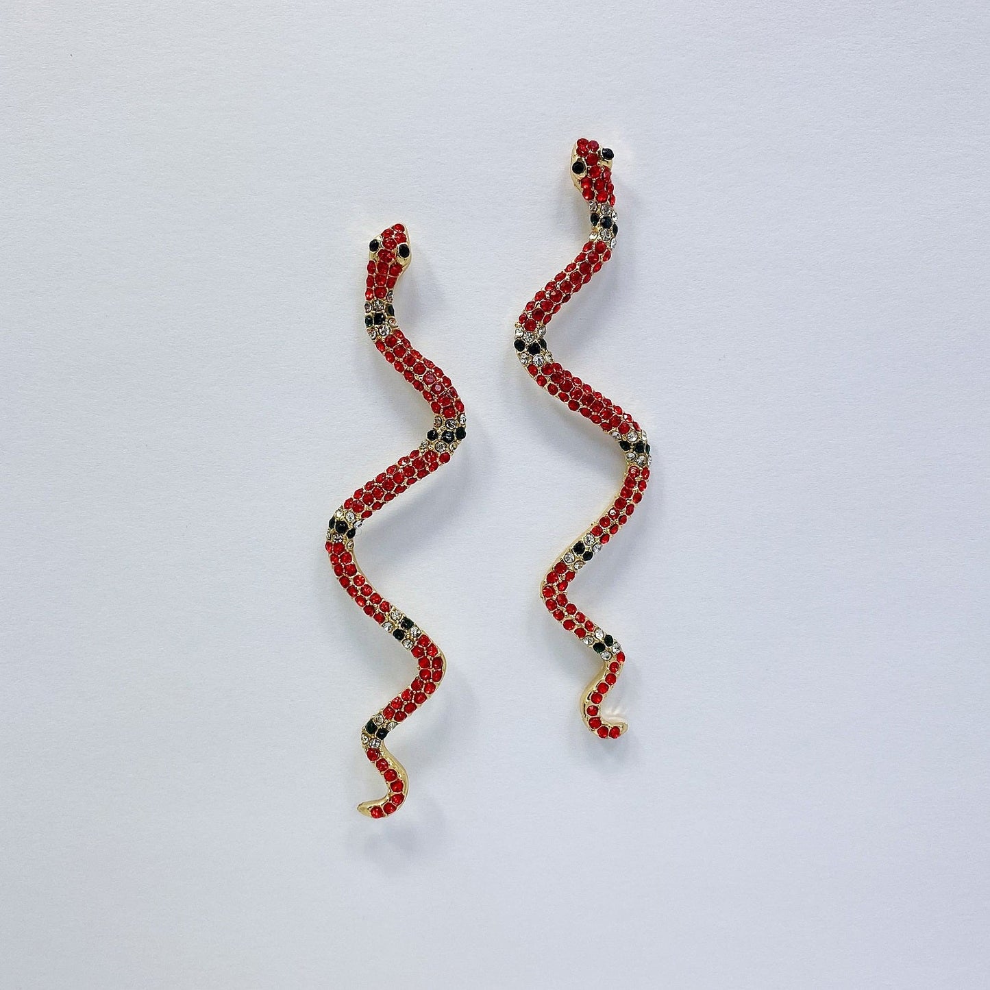 A pair of snake earrings on a white background