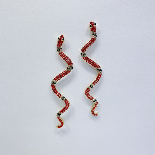 A pair of snake earrings on a white background