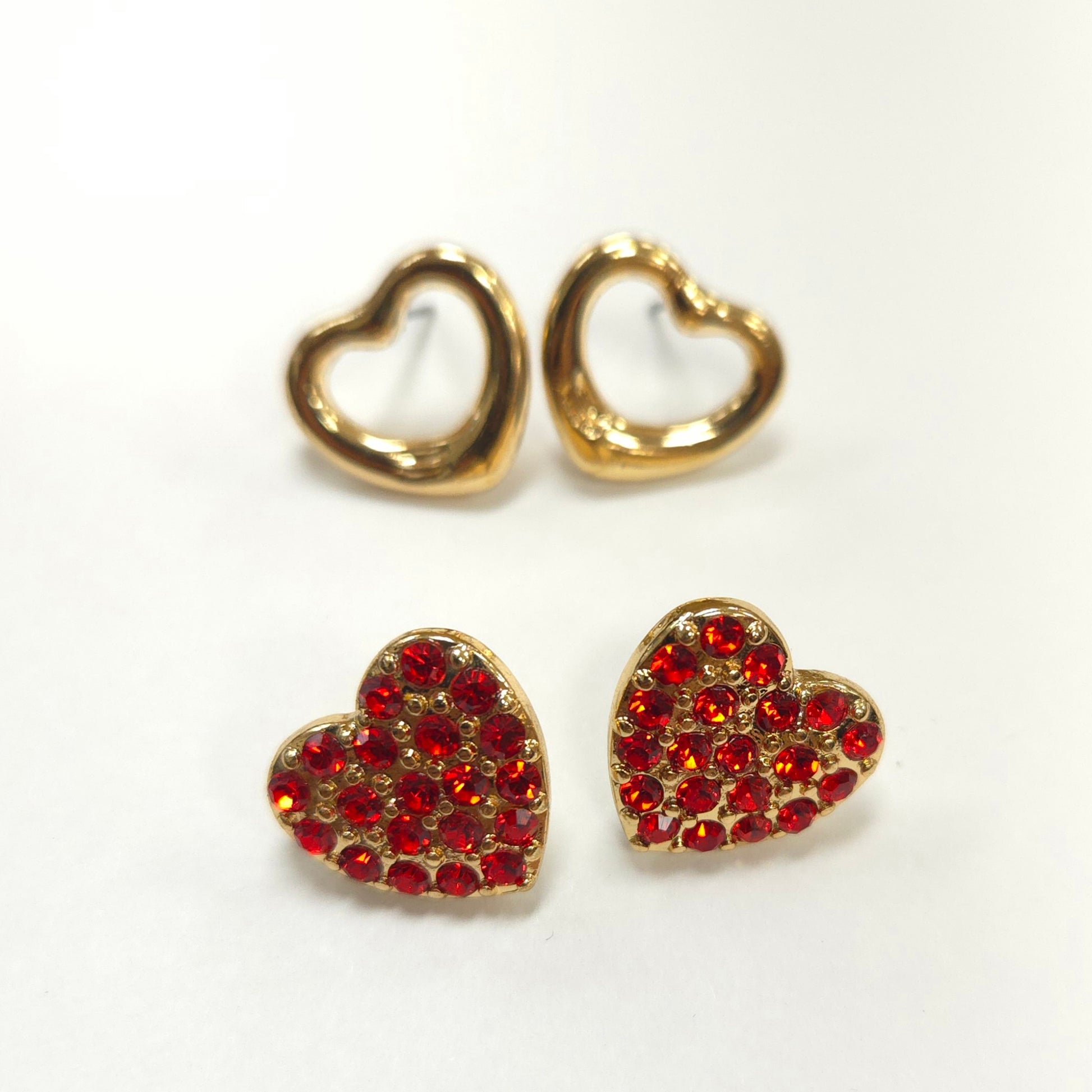 Heart-shaped earrings with red gemstones on a white background