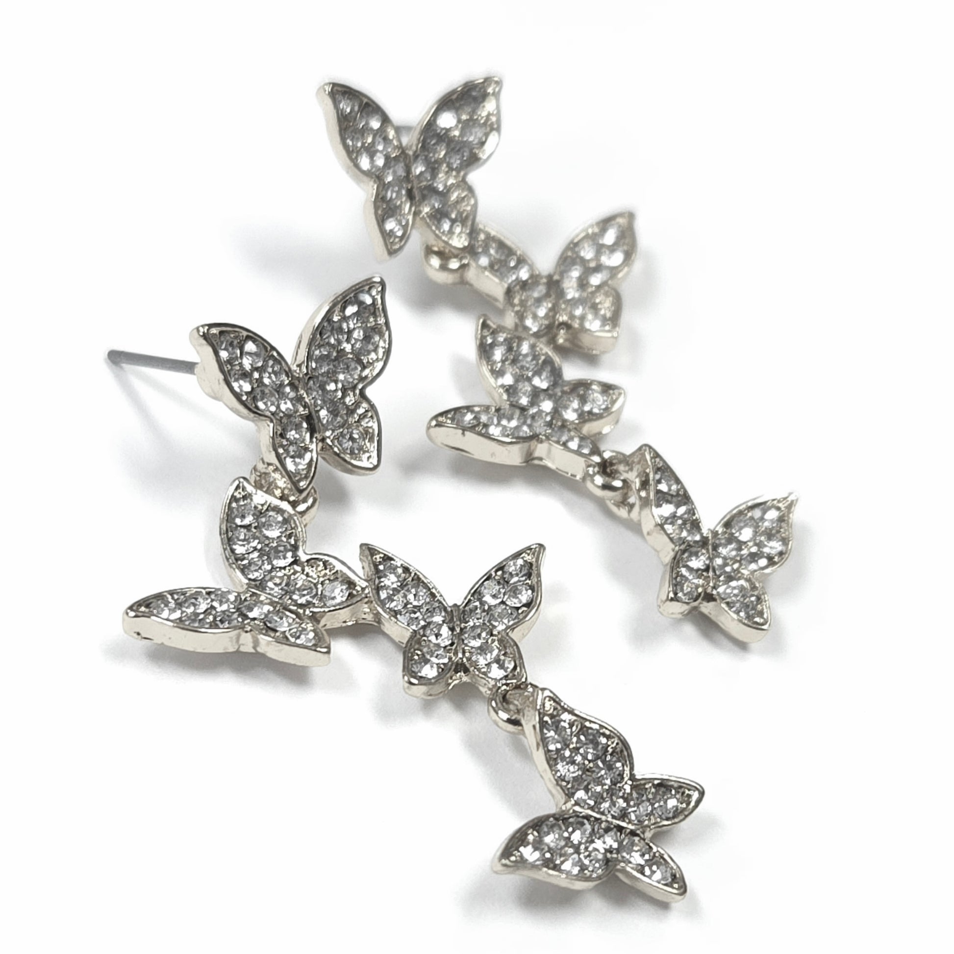 Butterfly-shaped earrings with clear gemstones on a white background