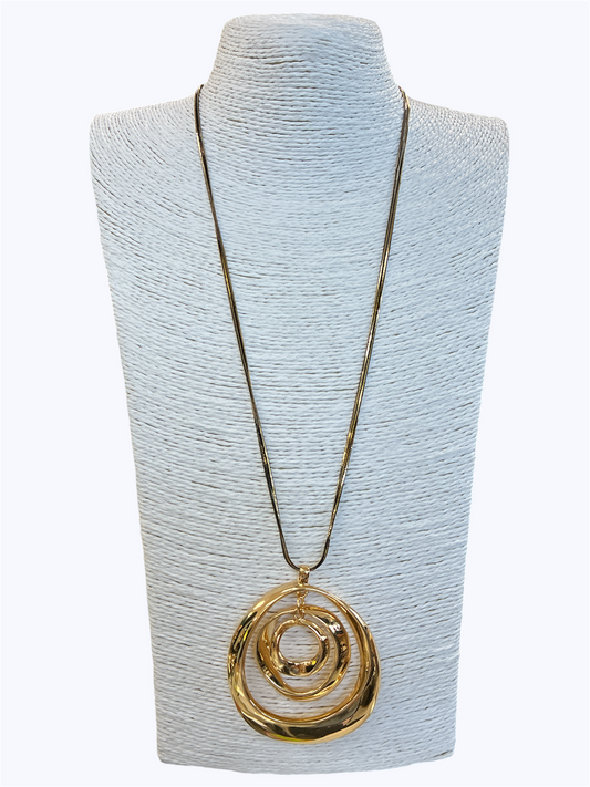 Gold necklace with a spiral pendant on a light blue mannequin bust.