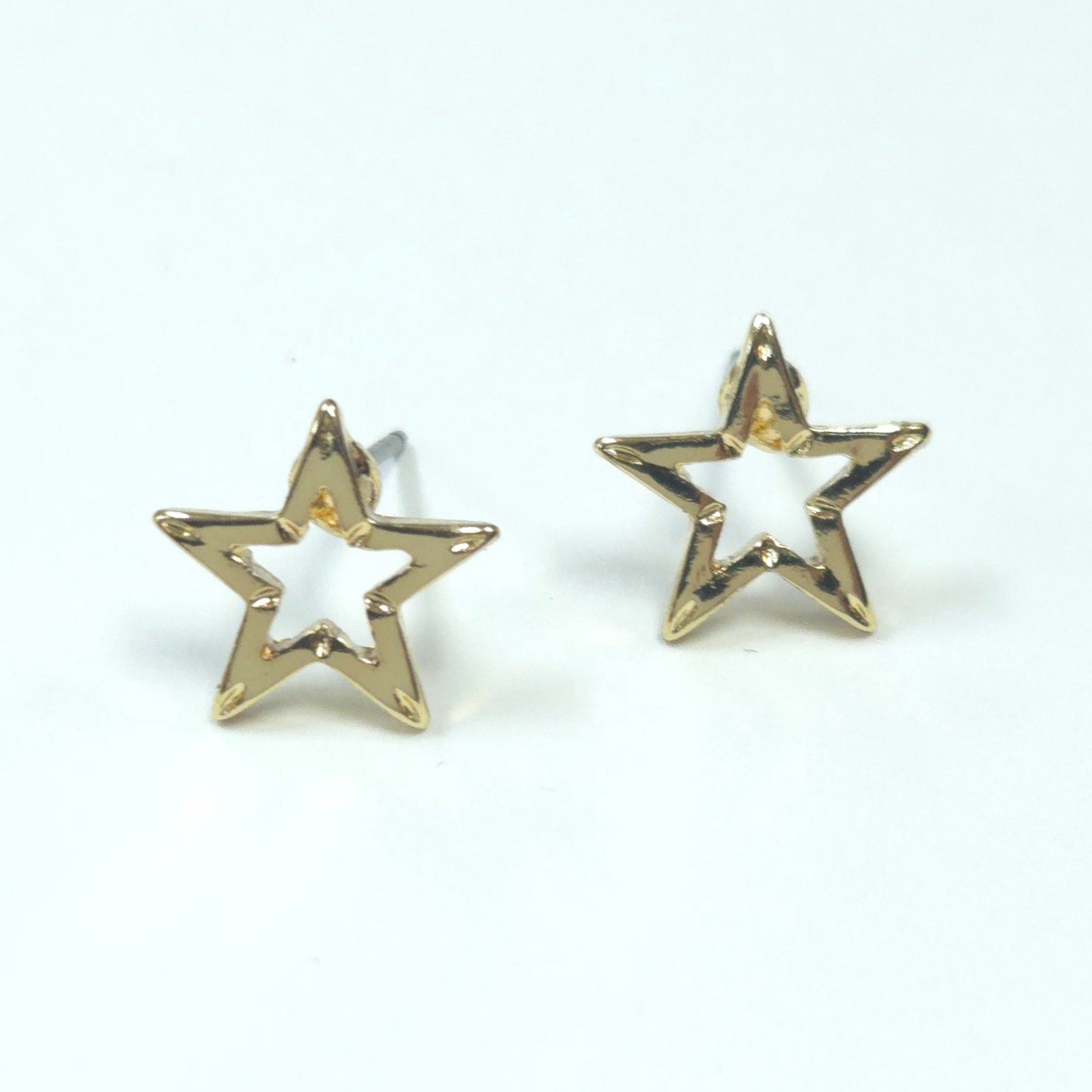 Gold star-shaped earrings on a white background