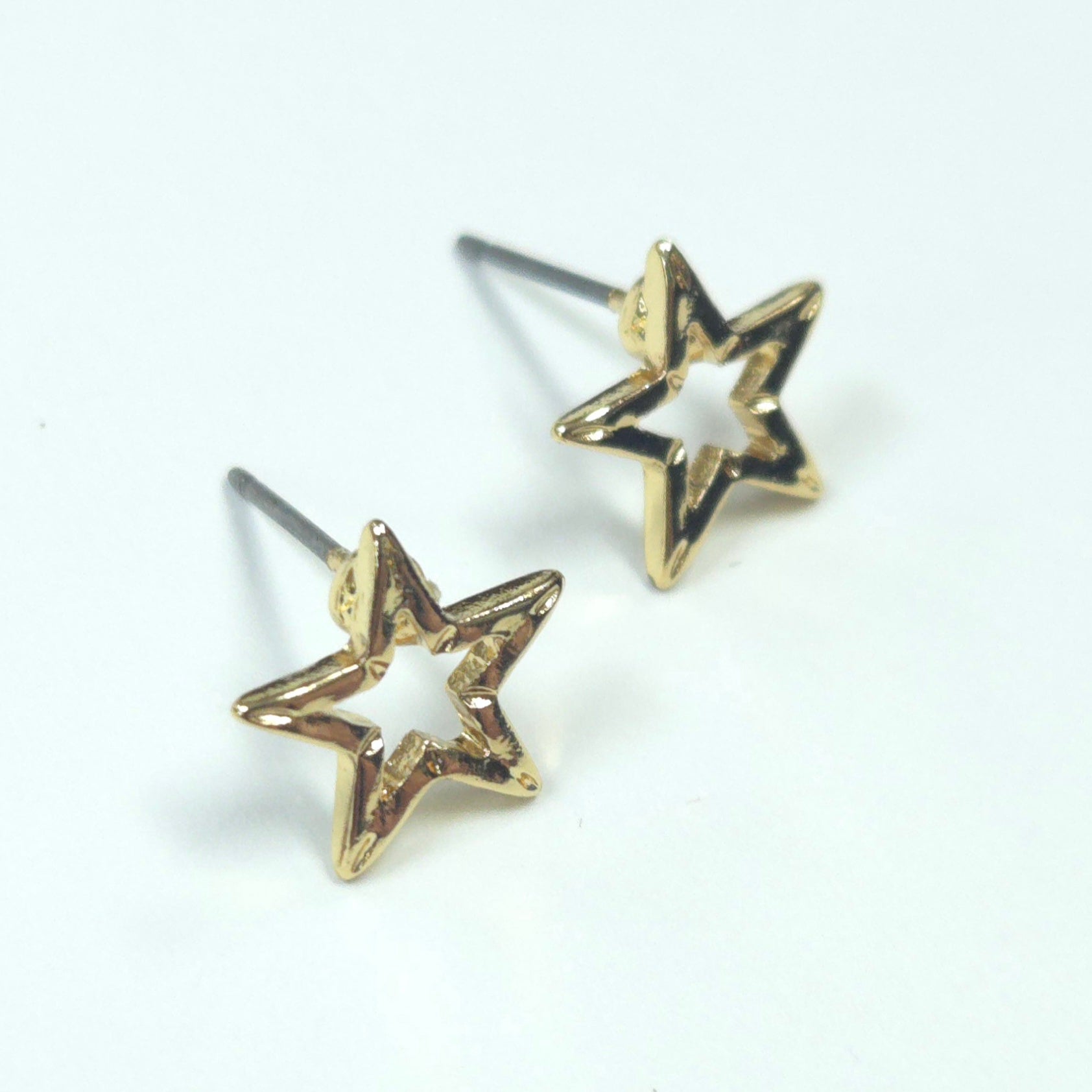 Gold star-shaped earrings on a white background