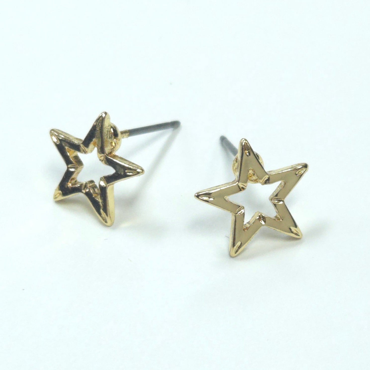 Gold star-shaped earrings on a white background