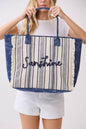 Person holding a striped tote bag with 'Sunshine' text on a white background