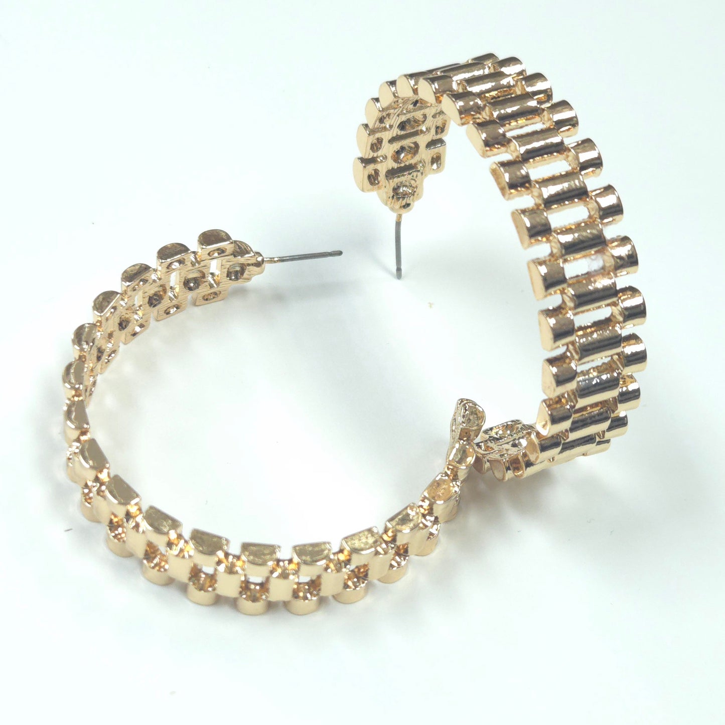 Gold hoop earrings with embedded stones on a white background
