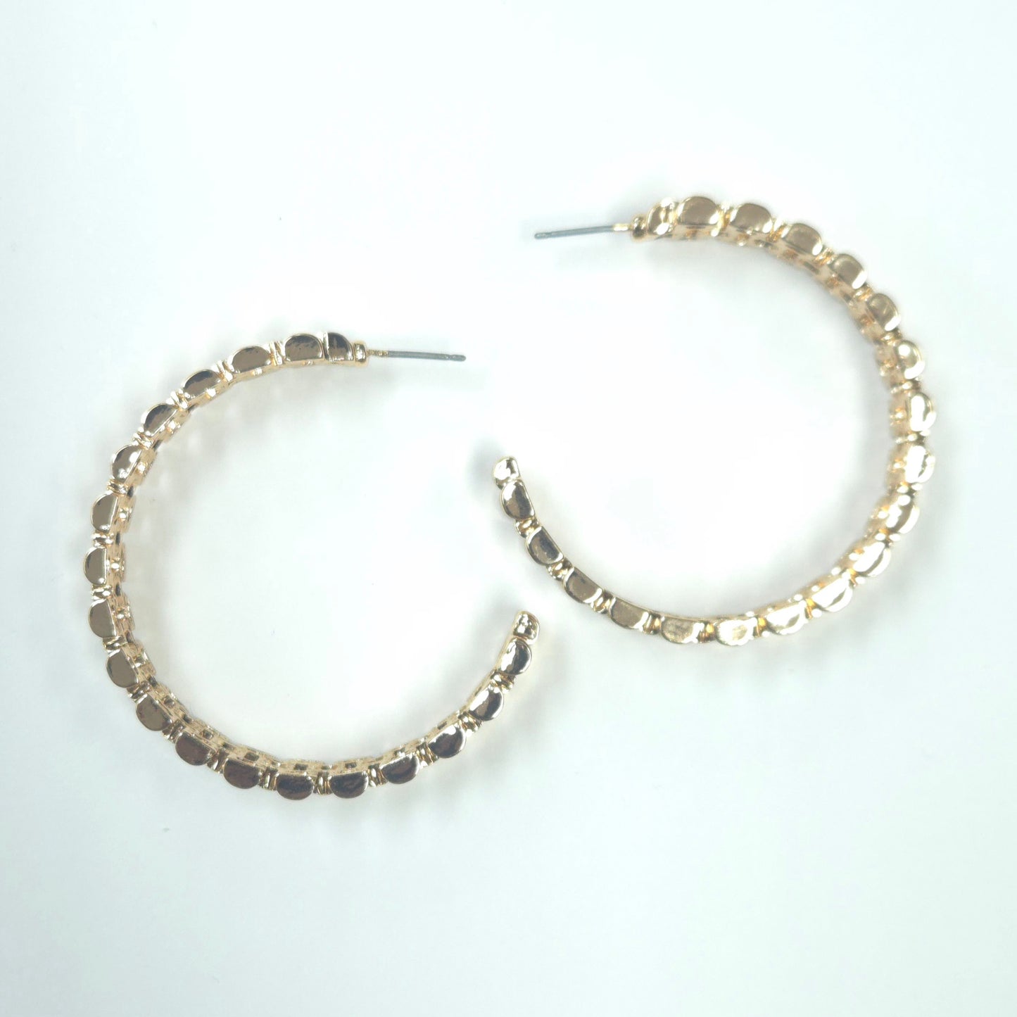 Gold hoop earrings with embedded stones on a white background