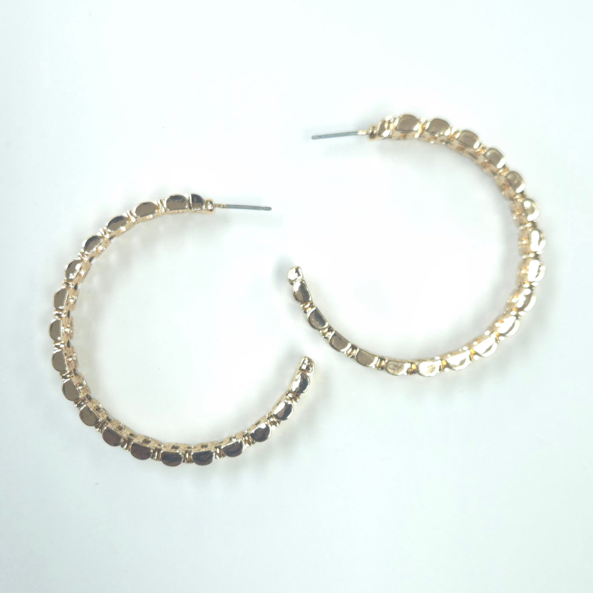 Gold hoop earrings with embedded stones on a white background