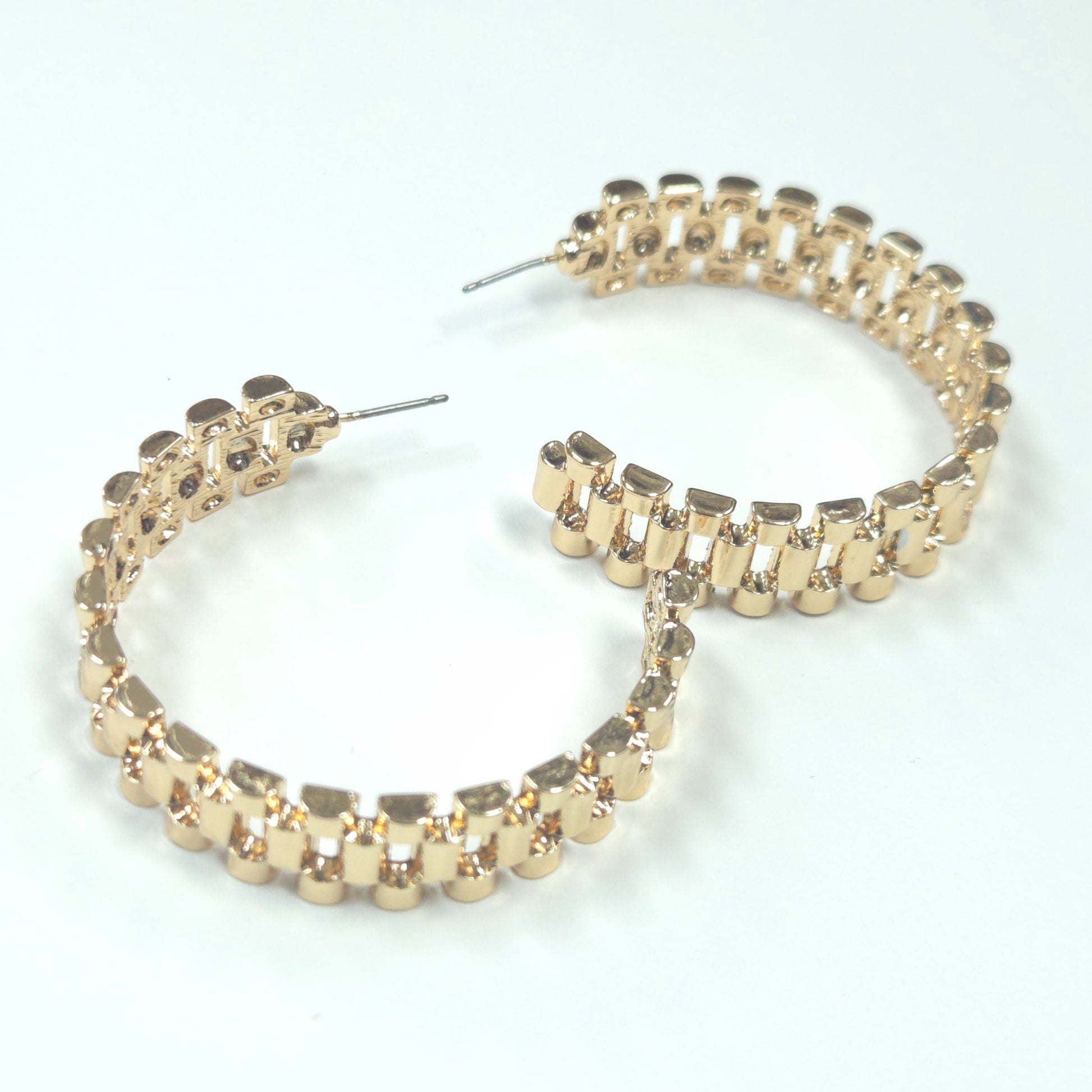 Gold hoop earrings with embedded stones on a white background
