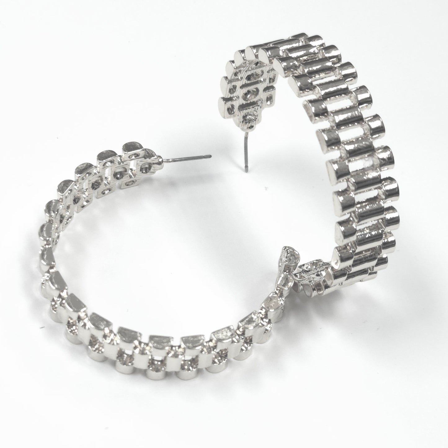 Silver hoop earrings with clear gemstones on a white background