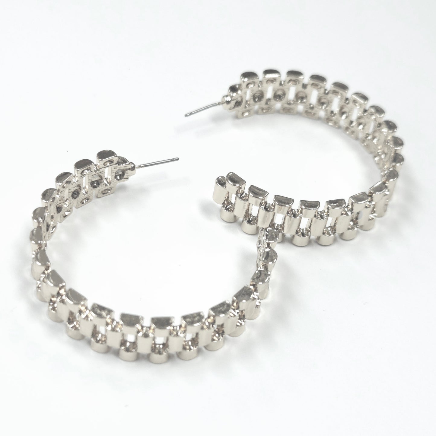 Silver hoop earrings with embedded stones on a white background
