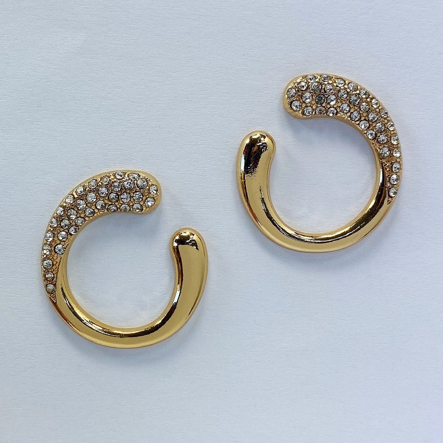 A gold earrings in a white background