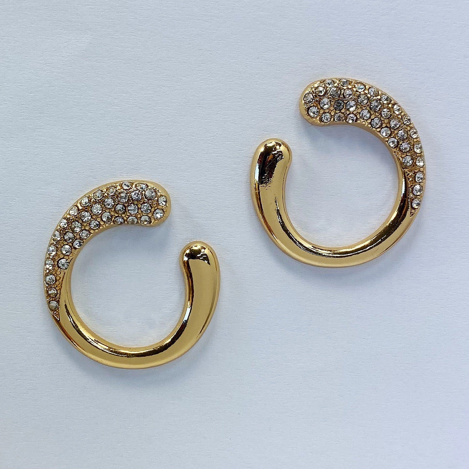 A gold earrings in a white background