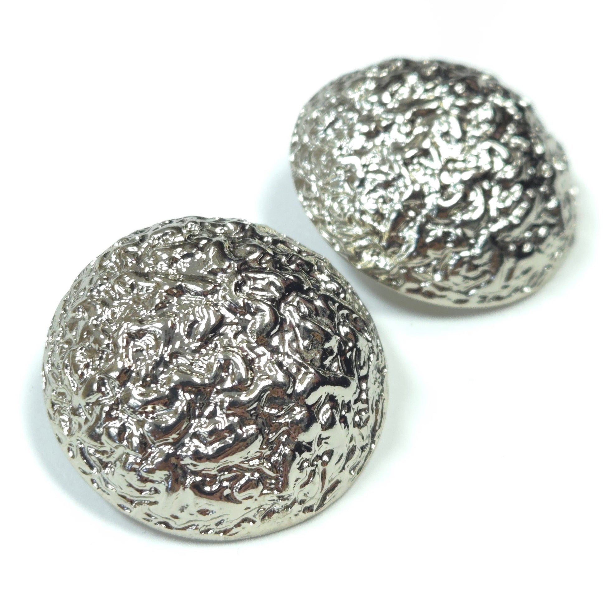 Two silver textured buttons on a white background