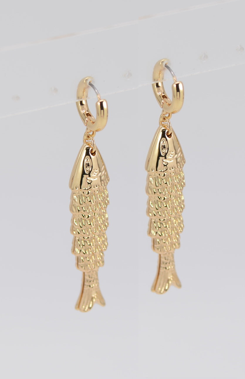 Gold fish-shaped earrings on a light gray background