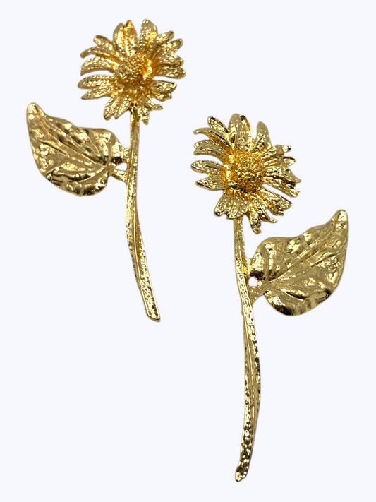 Gold floral statement earrings with textured daisy-inspired design and sculpted leaf accents for an elegant boutique-inspired look.