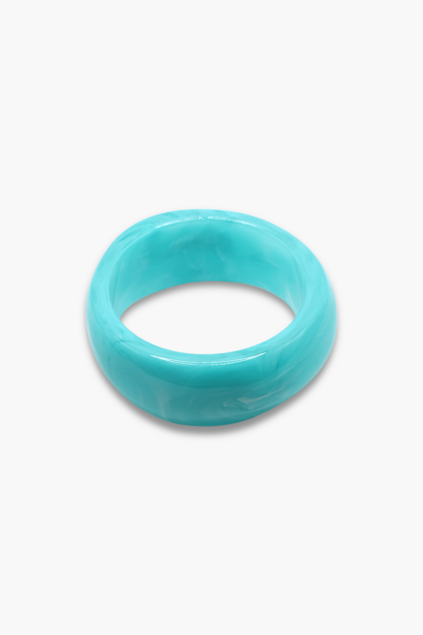 Glossy marbled resin bangle bracelet with chunky rounded silhouette and polished finish.