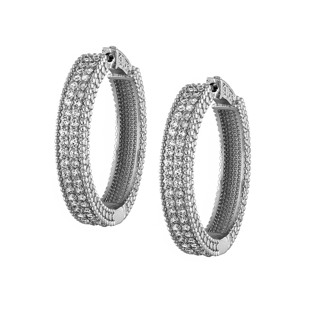 Pair of silver hoop earrings with clear stones on a white background