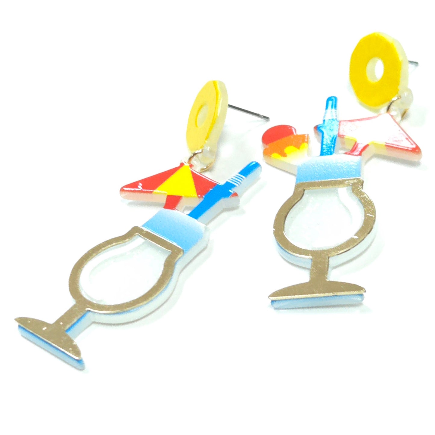 Colorful earrings shaped like cocktail glasses and straws on a white background