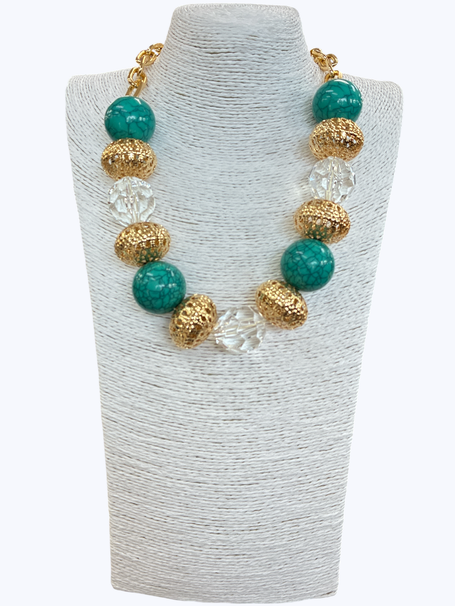Chunky boutique necklace featuring turquoise-style marbled beads, textured metallic accent beads, and clear faceted beads on gold chain.