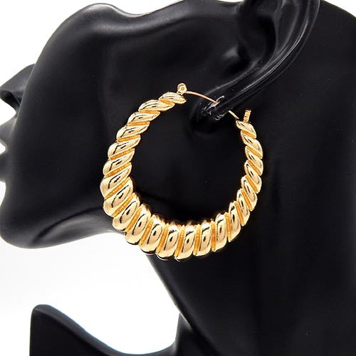 Close-up of ribbed twisted hoop earrings with textured spiral design on mannequin display