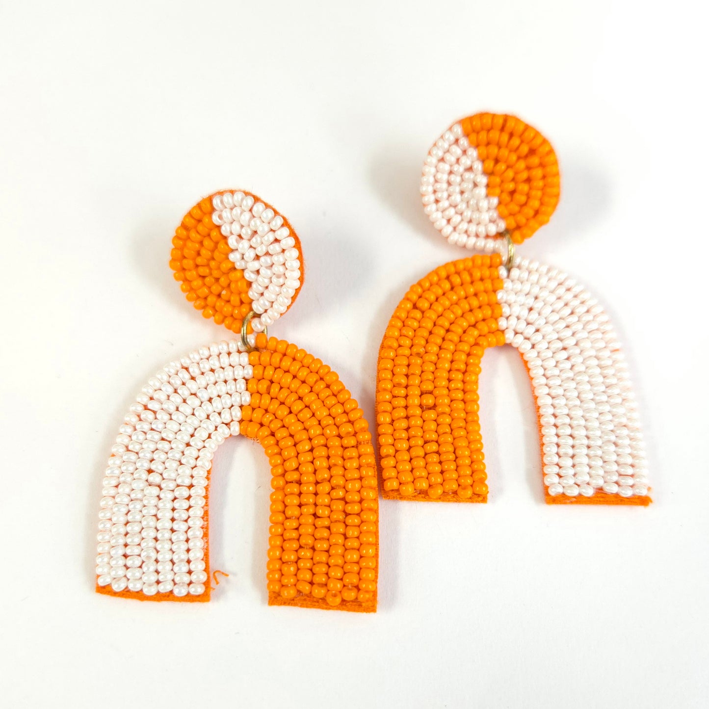 Pair of orange and white beaded earrings on a white background