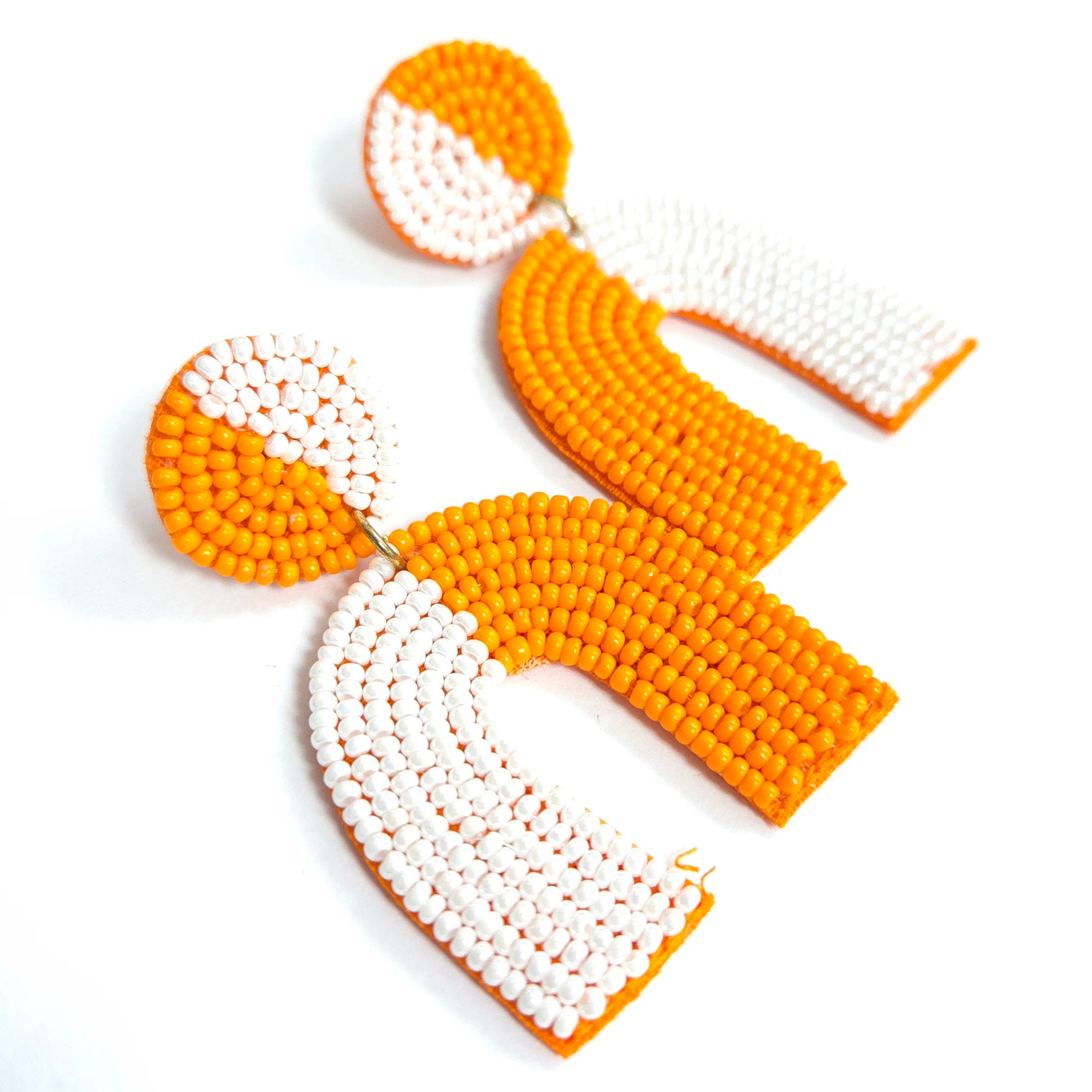 Pair of orange and white beaded earrings on a white background