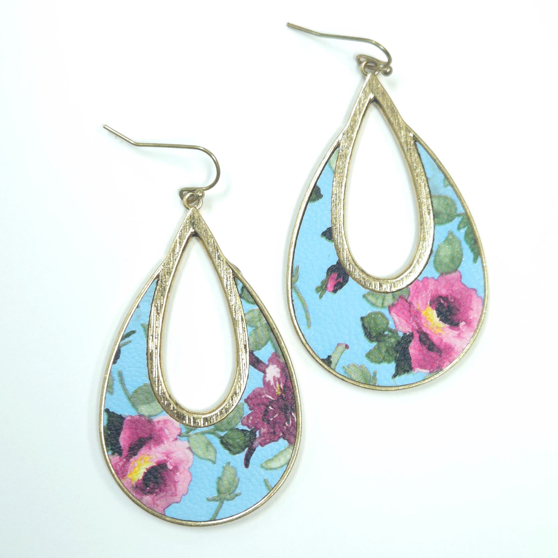 Teardrop-shaped earrings with floral design on a blue background