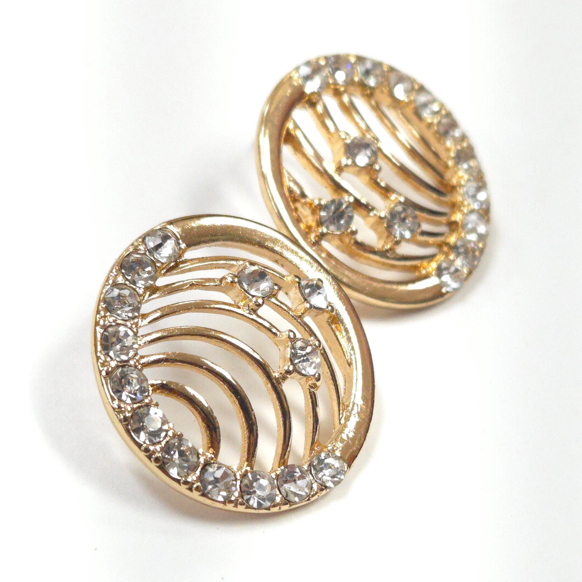 Gold earrings with crystal embellishments on a white background