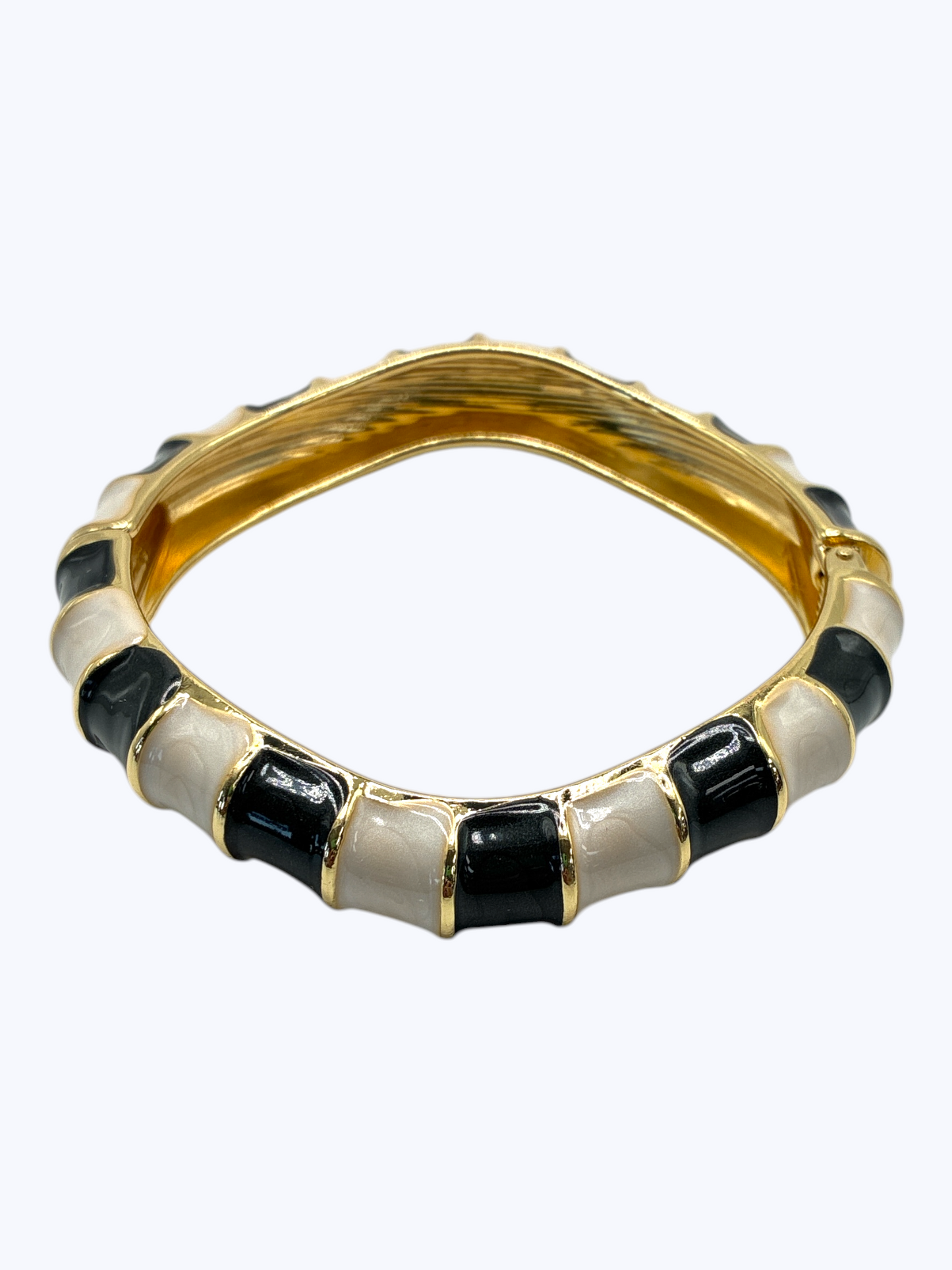 Gold ring with black and white stones on a white background