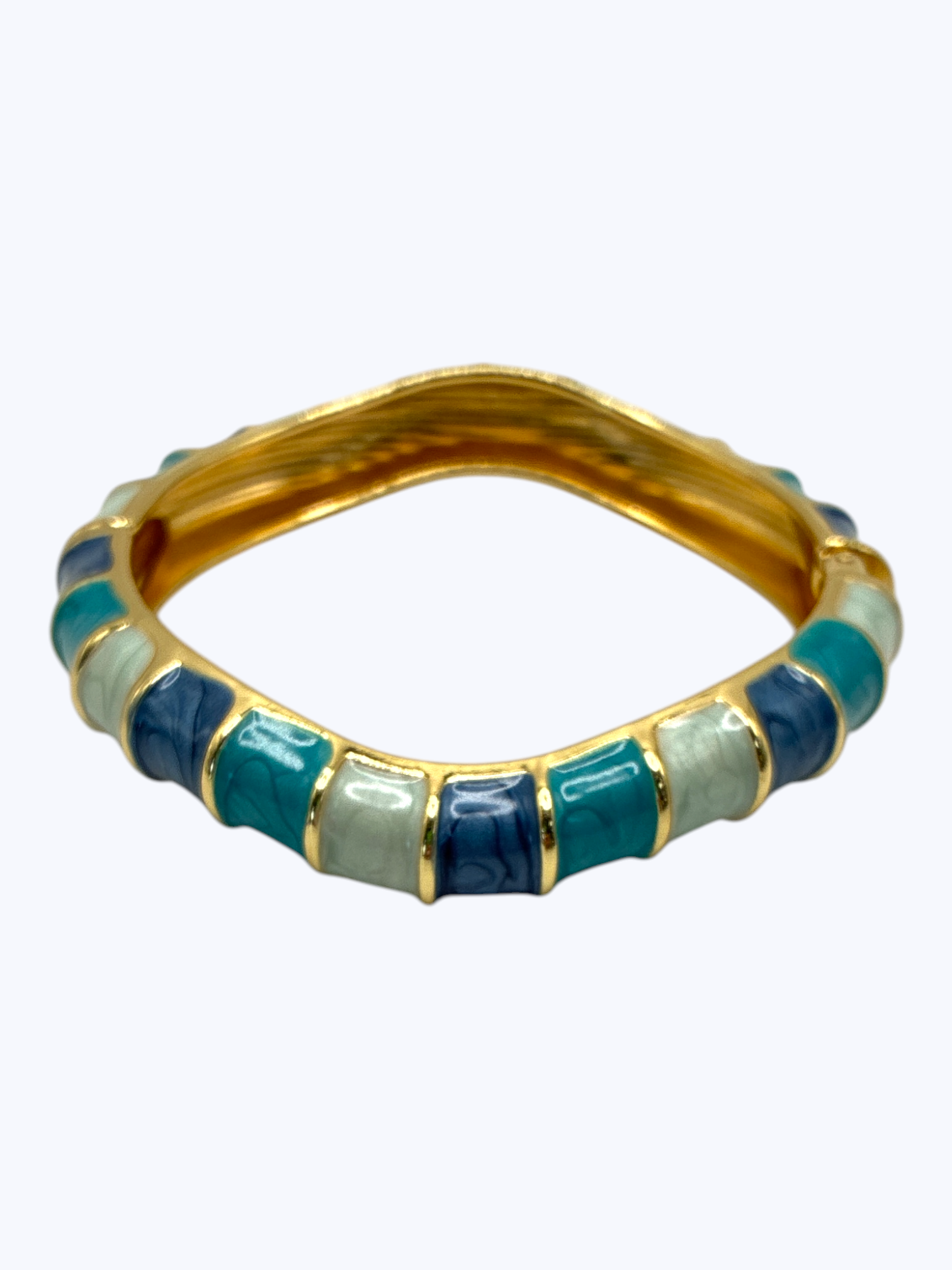 Gold bangle with blue and green stones on a white background