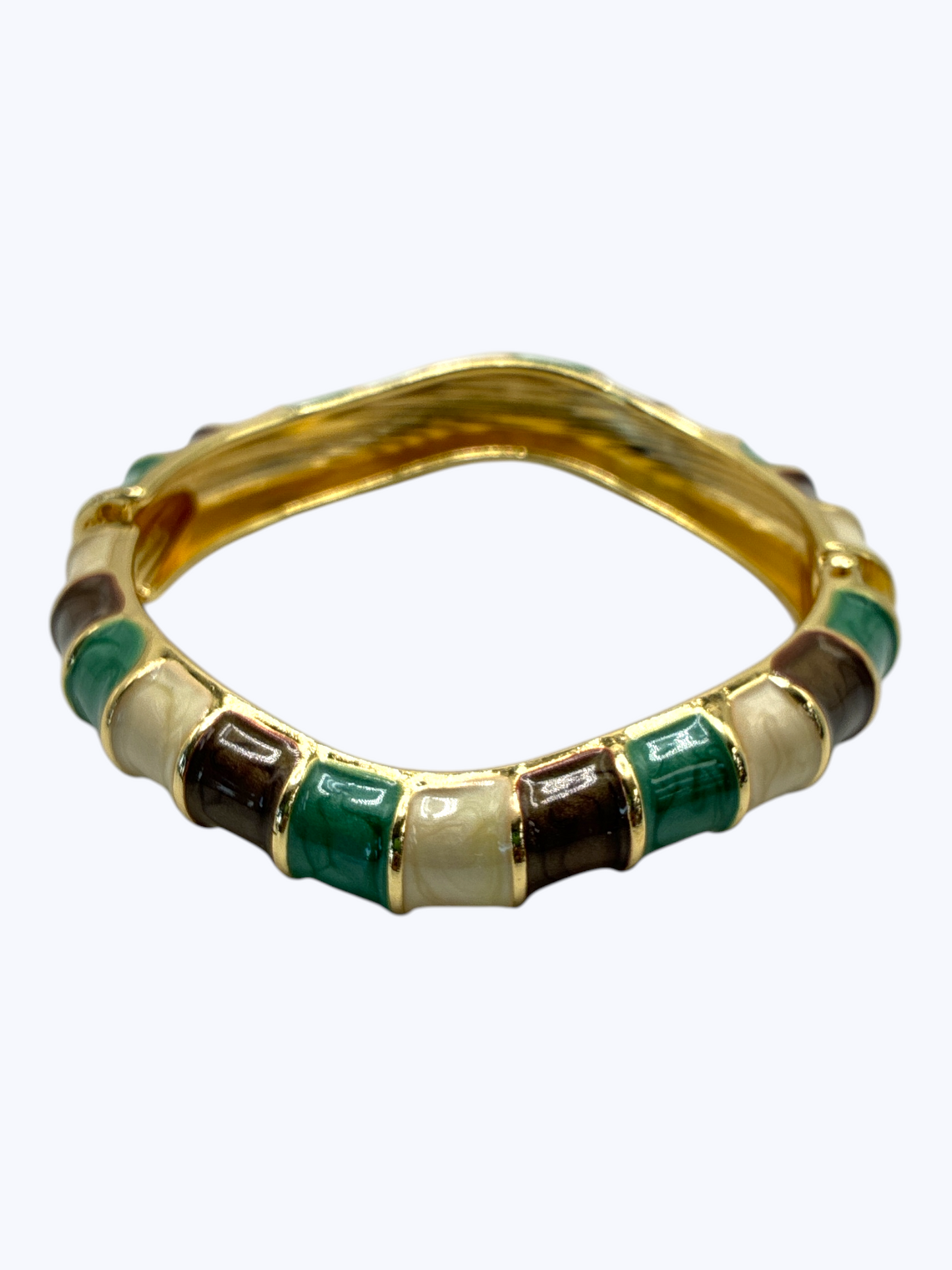 Gold ring with green and white gemstones on a white background