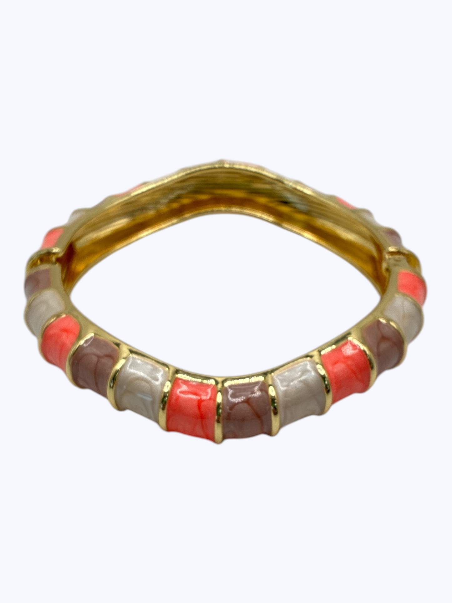 Gold ring with red and beige stones on a white background