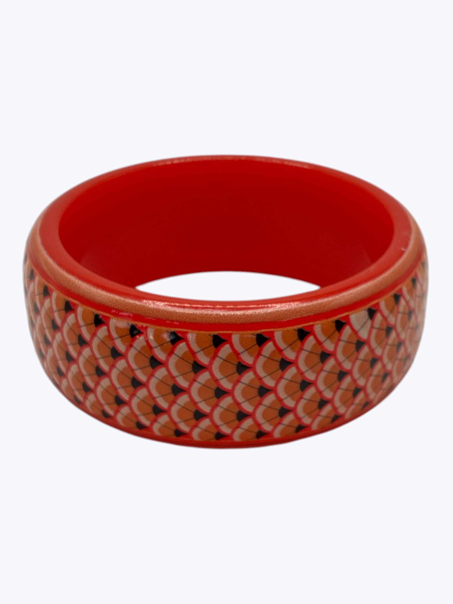 Red bangle with a patterned design on a white background
