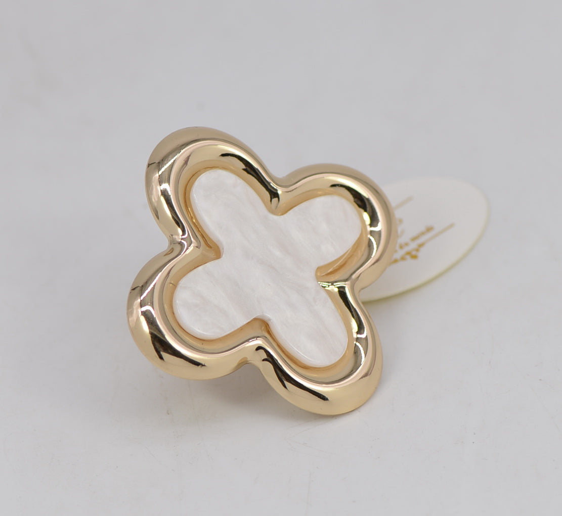 Gold four-leaf clover-shaped ring on a light gray background