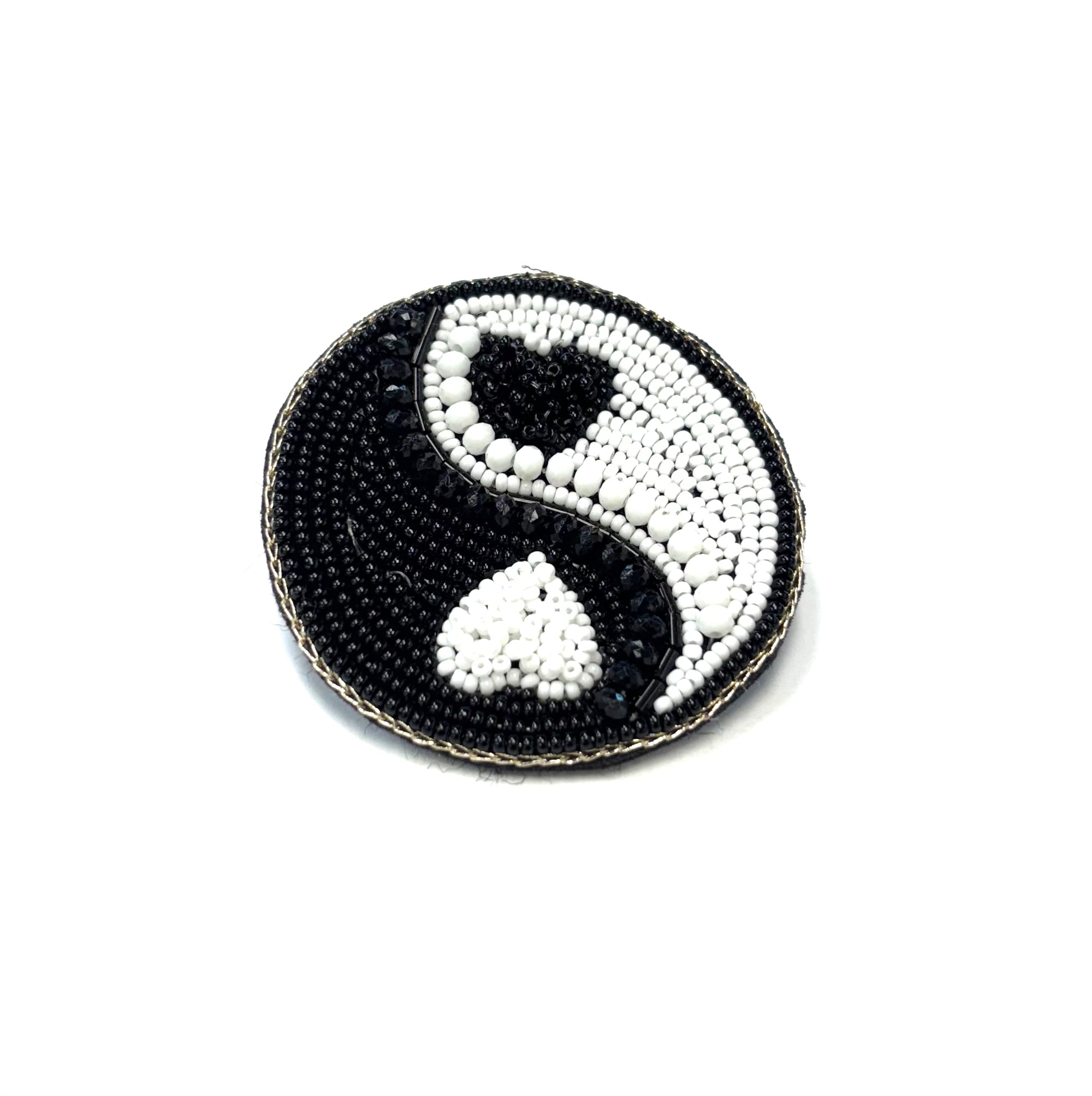 Beaded yin yang symbol on a white background