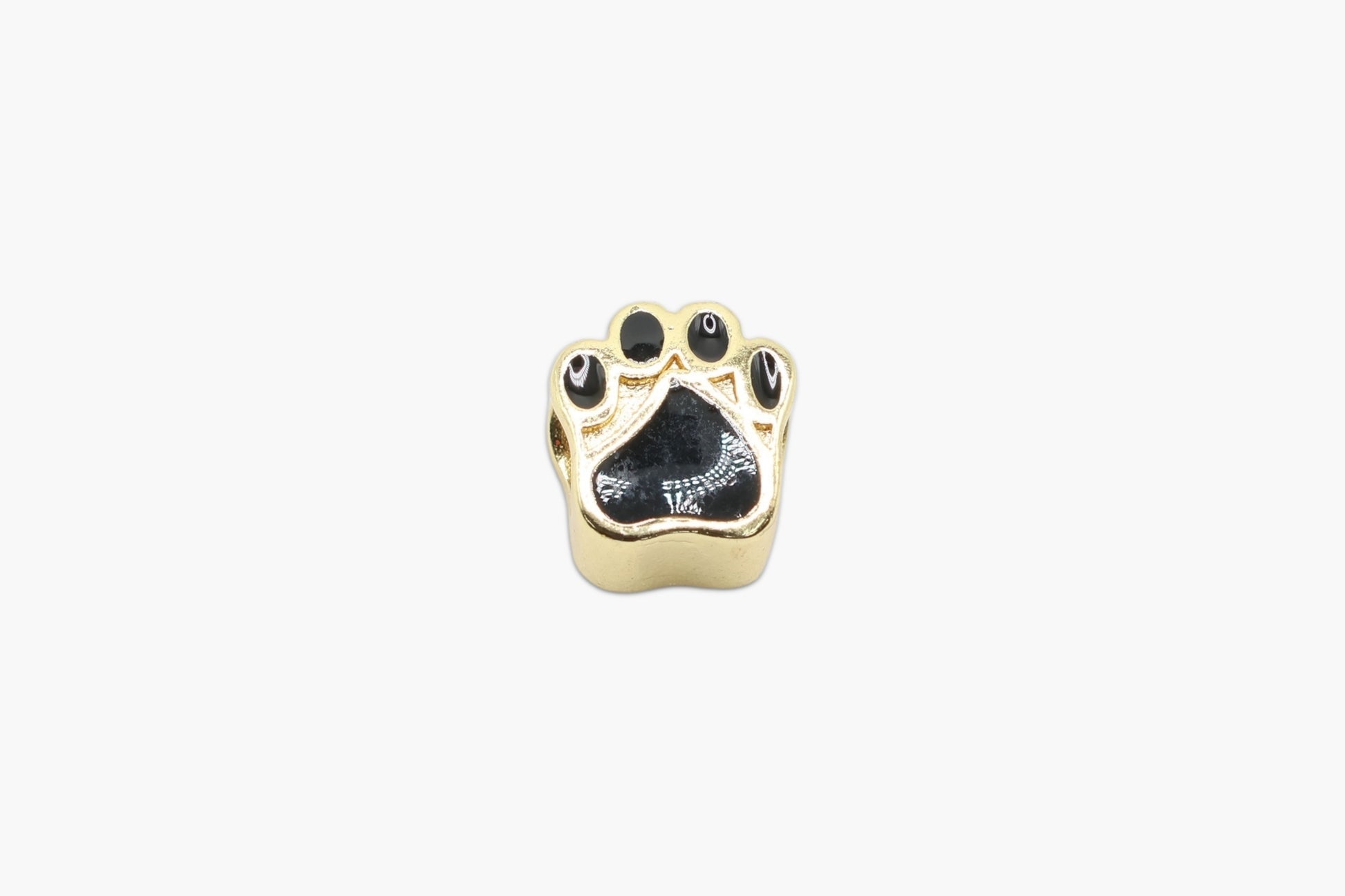 Gold paw print charm on a white background
