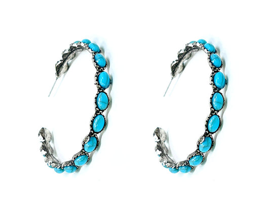 Pair of hoop earrings with turquoise stones on a white background