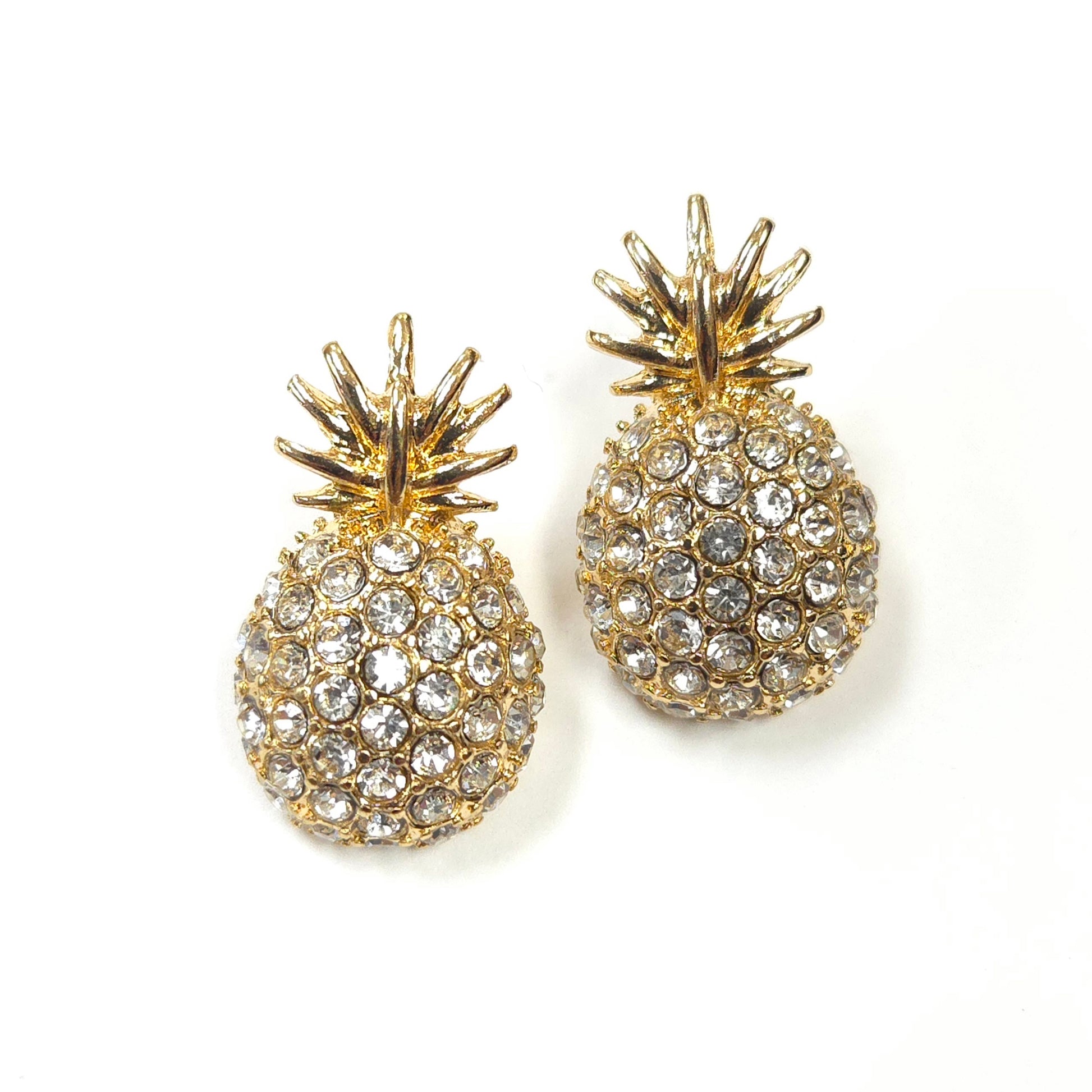 Gold pineapple earrings with crystal details on a white background