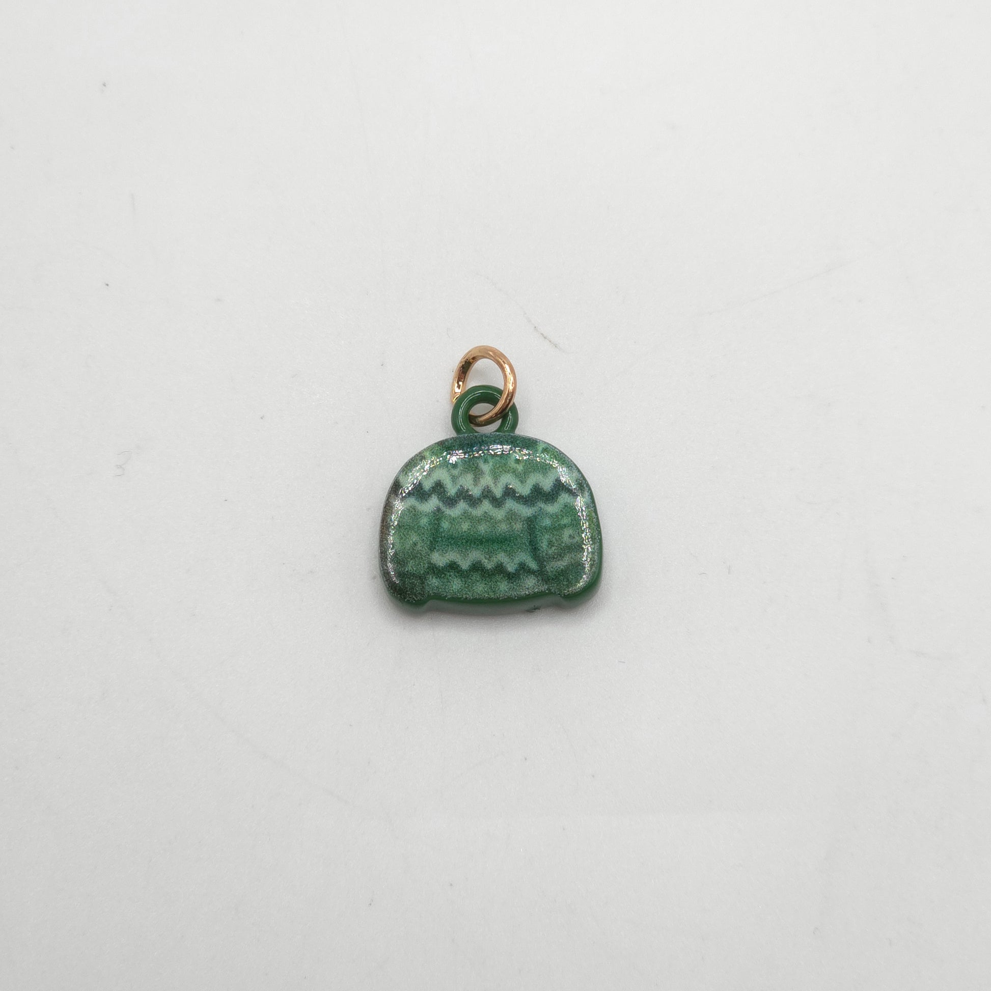Green ceramic charm with gold loop on a white background