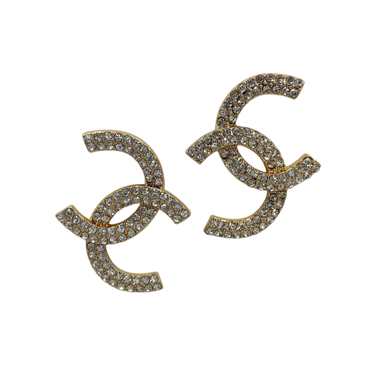 Gold earrings with rhinestone embellishments on a white background