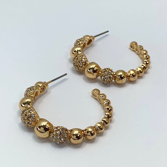 A pair of gold earrings on a white background