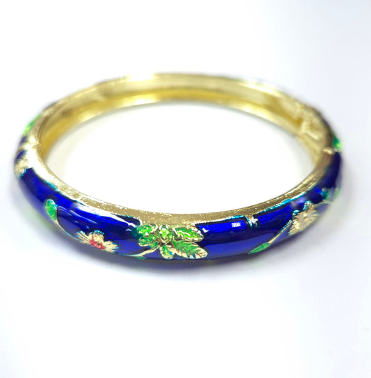 Gold and blue bangle with floral design on a white background