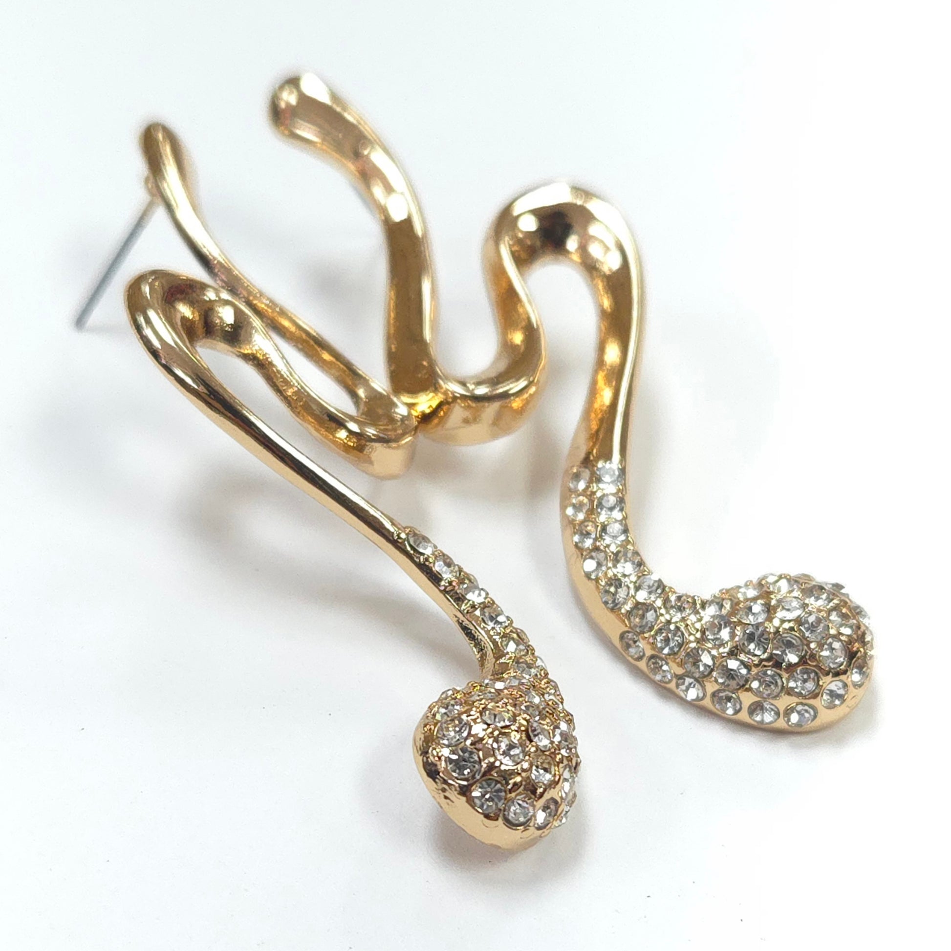 Gold earrings with intricate designs on a white background