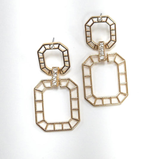 Gold geometric earrings with clear stones on a white background