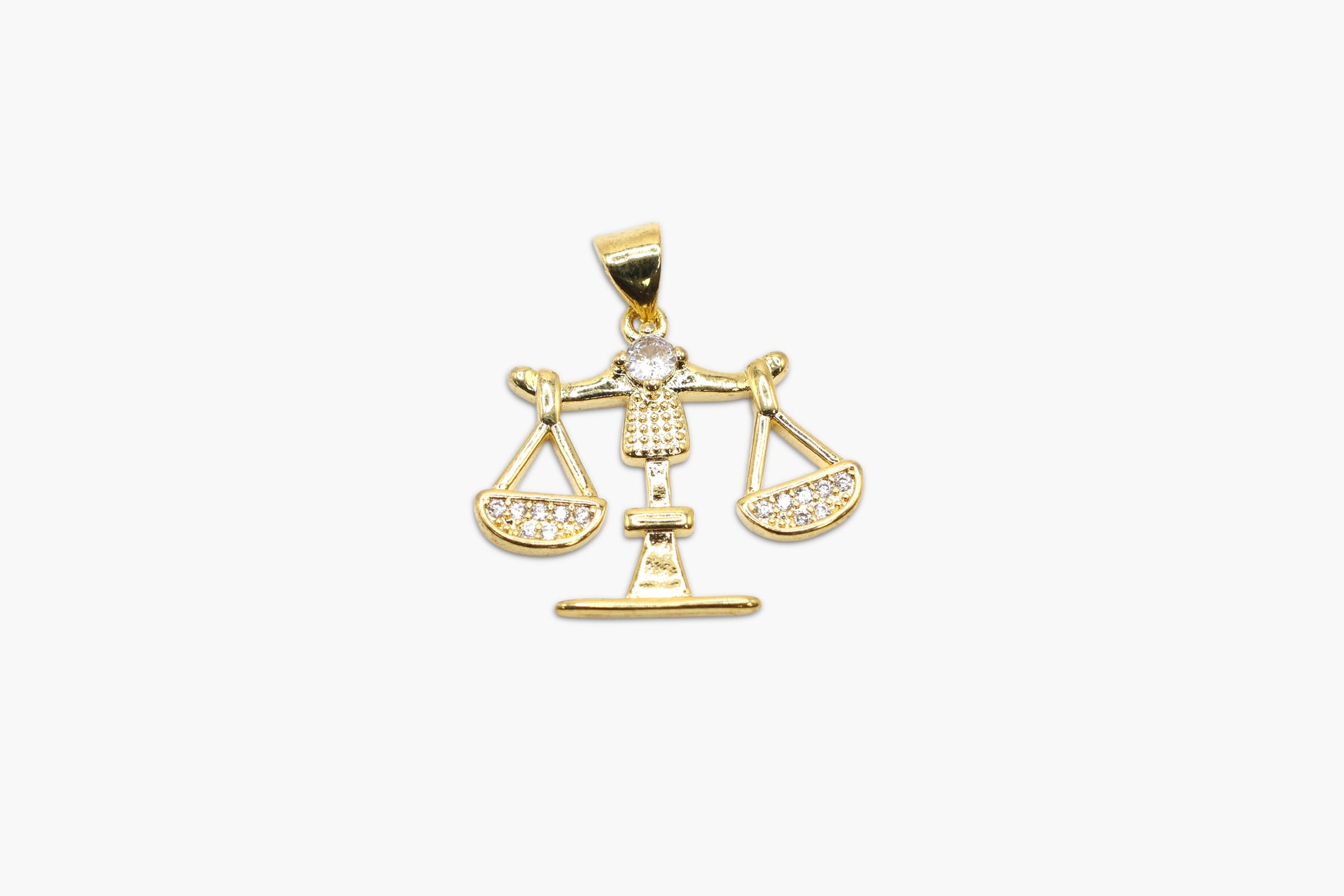Gold pendant with a Libra design on a white background